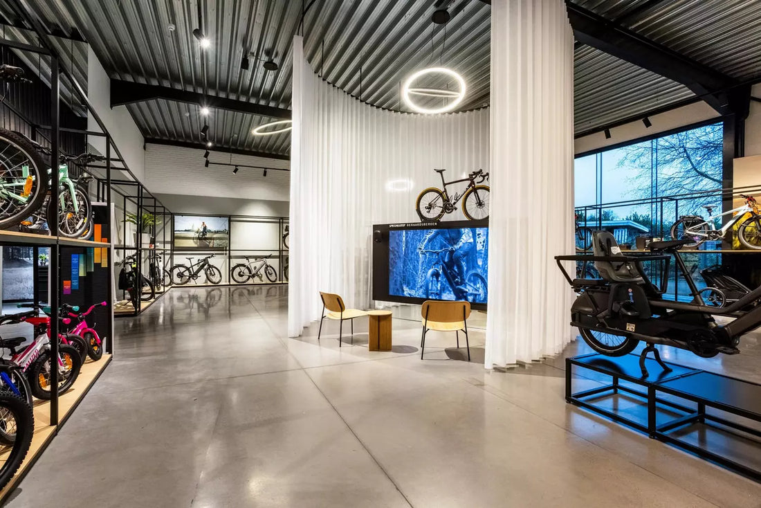 Modern bicycle showroom from specialized with various bikes on display, seating area, and large digital screen