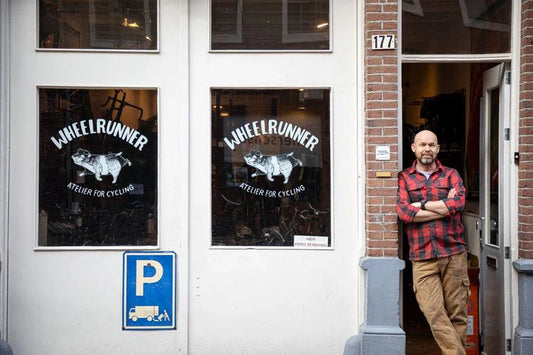 A man standing at the entrance doors of Wheelrunner bicycle shop.