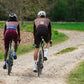 Two cyclists riding a gravel road